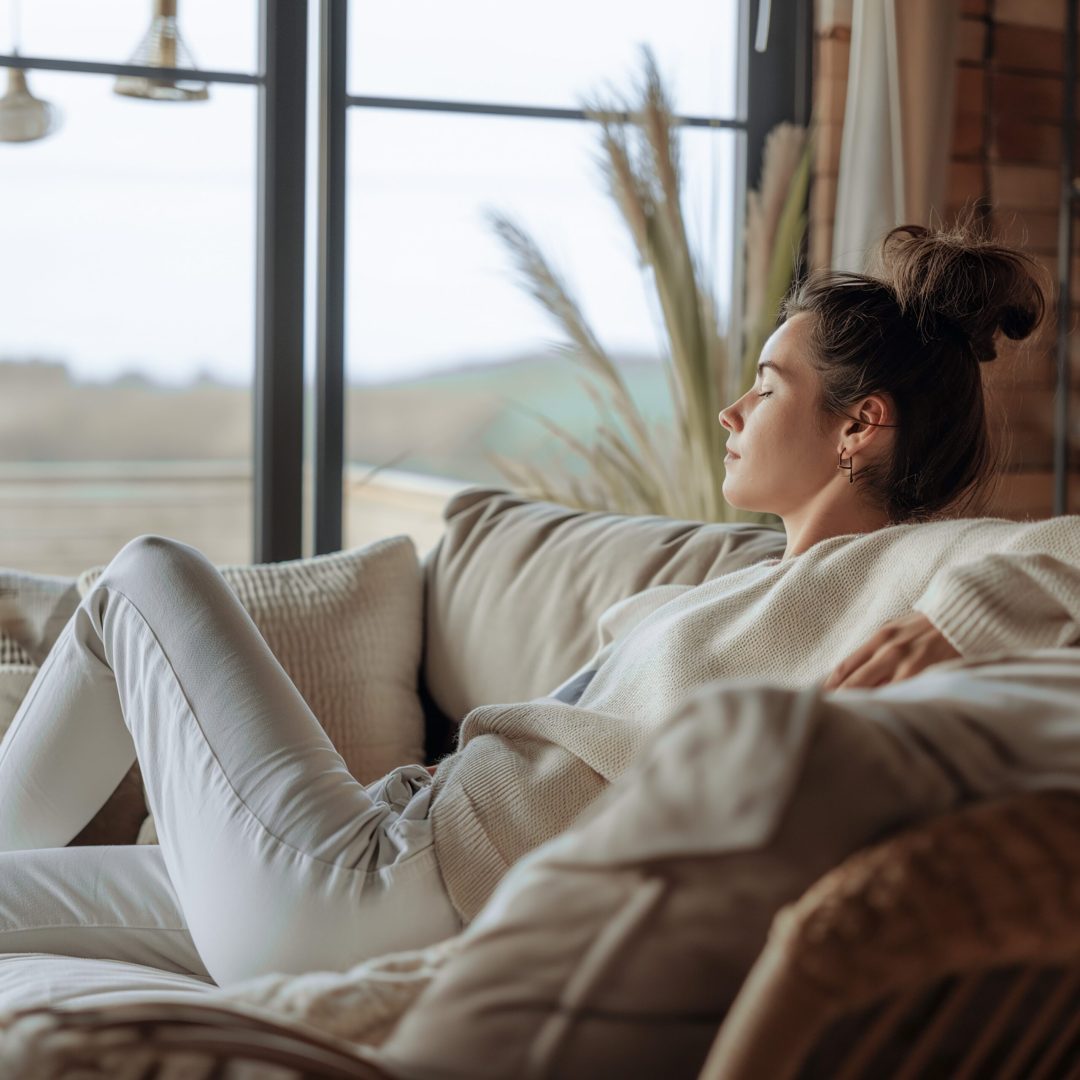 A young woman reads a book on a sofa in the living room, a student reviews lessons to prepare for an exam, a teenage girl wears a yellow shirt sitting on a sofa, AI generates.